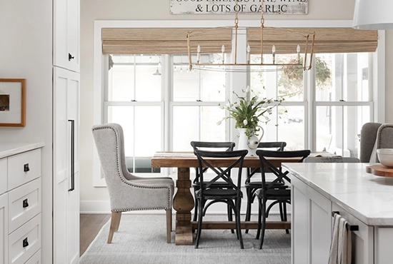 Bright kitchen and dining area with farmhouse table and large windows by Northern Illinois Home Builders Association members